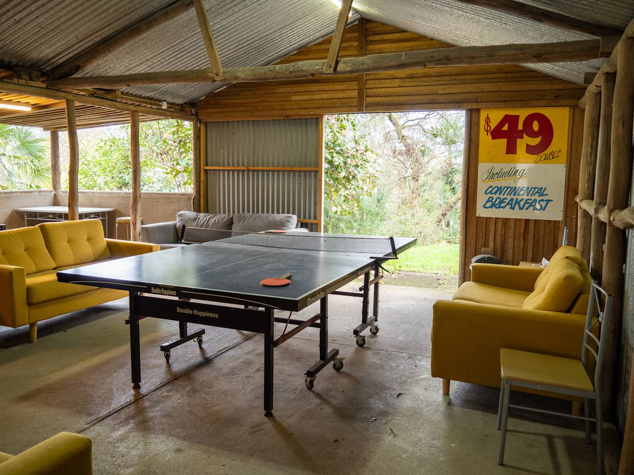 The games room: a table tennis table between yellow couches, open to the garden